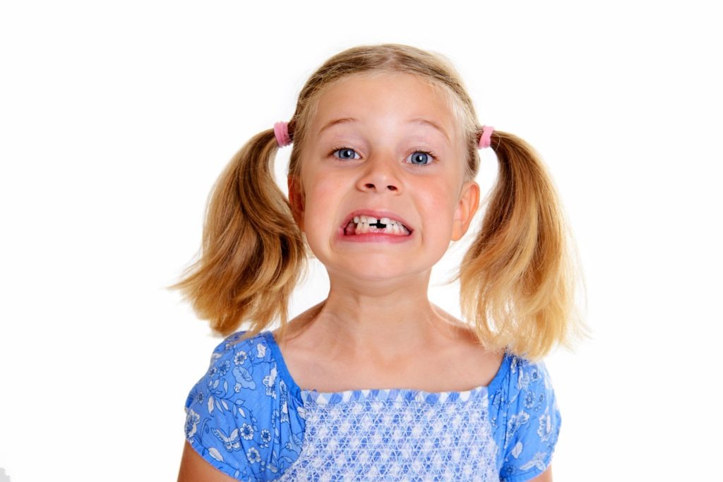 young girl with missing teeth and pig tails