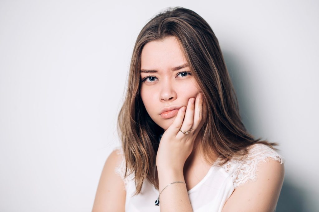 girl holding her mouth