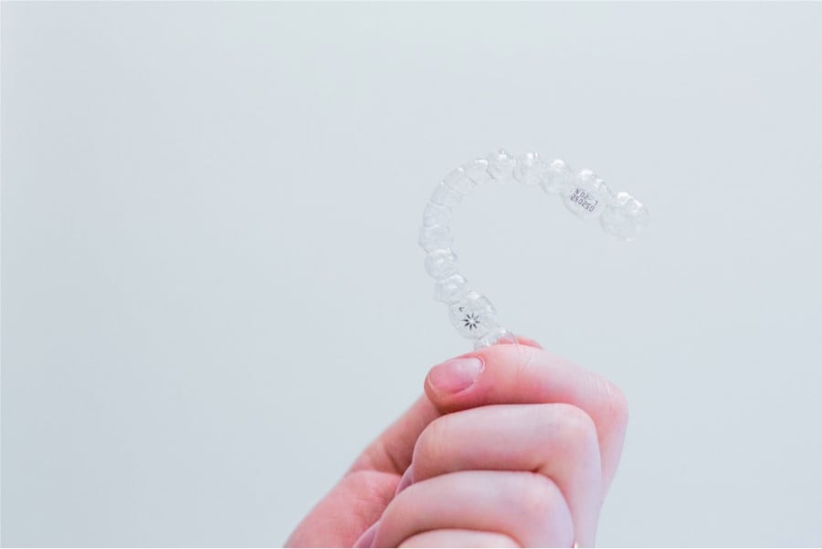 photo of hand holding an Invisalign aligner